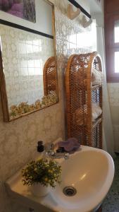 baño con lavabo, espejo y cestas de mimbre en Fonda Felip en Port de la Selva