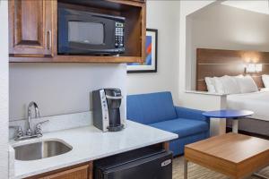 a small kitchen with a sink and a microwave at Holiday Inn Express & Suites Texarkana by IHG in Texarkana