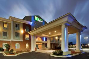 un edificio de hotel con un letrero iluminado en él en Holiday Inn Express and Suites Thomasville, an IHG Hotel, en Thomasville