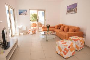 uma sala de estar com um sofá e uma mesa em Villa Pomelo em Protaras