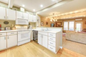 eine Küche mit weißen Geräten und ein Wohnzimmer in der Unterkunft Leinemann Ski Haus in McHenry