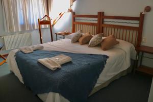 Un dormitorio con una cama con dos toallas encima. en Hosteria Las Garzas, en Villa La Angostura 38 fotos más