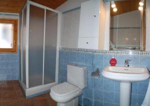 Un baño con azulejos azules, inodoro y lavabo. en Casa La Catalina, en Beceite
