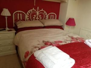 Schlafzimmer mit einem großen Bett mit roten Wänden in der Unterkunft Waverley in York