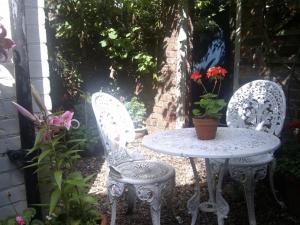 two white chairs and a table with a potted plant at Waverley in York