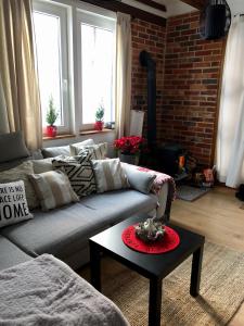 a living room with a couch and a table at Domek pod lasem in Pasłęk