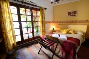 a bedroom with a bed and a large window at Hosteria Amparo in Neuquén