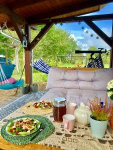 a table with plates of food on top at Domek pod lasem in Pasłęk