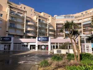 an empty parking lot in front of a building at LES CEDRES, Résidence LES OCEANES in Pornichet