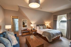 a hotel room with a bed and a couch at Oban Bay Hotel in Oban