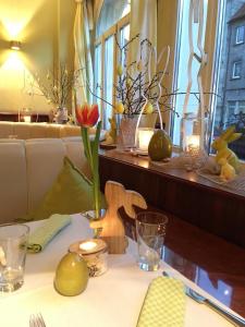a table with a table cloth with flowers and candles at Hotel Europa in Bamberg