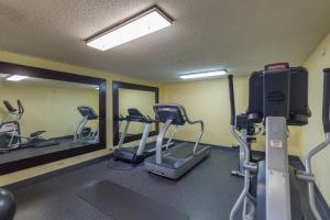 a gym with three treadmills and elliptical machines at Brandon Center Hotel in Tampa
