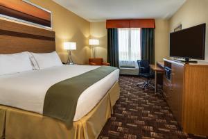 a hotel room with a bed and a flat screen tv at Holiday Inn Express Fort Lauderdale Airport South by IHG in Dania Beach