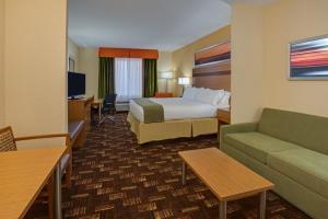 a hotel room with a bed and a couch at Holiday Inn Express Fort Lauderdale Airport South by IHG in Dania Beach +20 photos