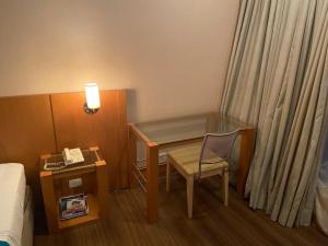 a room with a desk and a chair and a bed at AGA Nortel in Sao Paulo