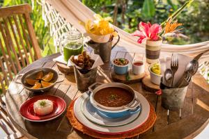a wooden table with bowls of food on it at Sierra Alta Finca Boutique in Minca