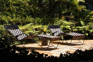 due sedie e un tavolo in giardino di Sierra Alta Finca Boutique a Minca
