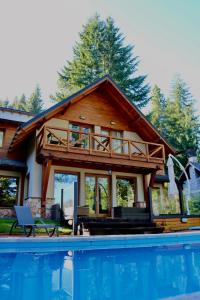 a house with a pool in front of it at Hosteria Las Garzas in Villa La Angostura