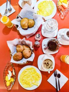 a table with plates of food on a red table at Hotel Makroz in Latacunga