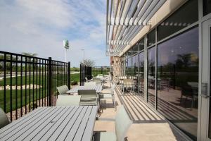 a restaurant with tables and chairs on a balcony at Holiday Inn Express & Suites Fond Du Lac by IHG in Fond du Lac