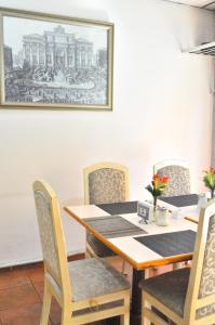 沙拉曼卡的住宿－Hotel Trevi，餐桌和椅子,墙上挂着照片