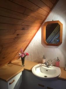 uma casa de banho com um lavatório e um vaso de flores num balcão em Heatherhill Chalet - Sea and mountain views em Keurboomstrand