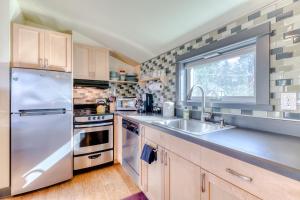 a kitchen with a stainless steel refrigerator and a sink at Upscale NE Portland Guesthouse in Portland