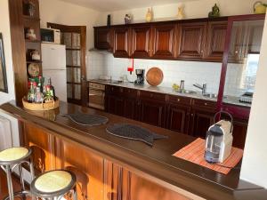 a kitchen with wooden cabinets and a counter top at Beachfront Apartment with Swimming Pool in Mindelo
