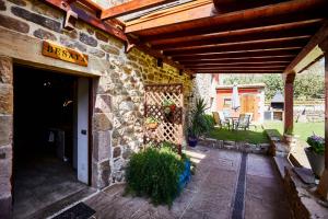 un edificio de piedra con techo de madera y patio en Sendero del Saja-Besaya, en Cobejo