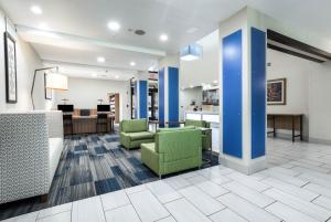 a lobby with two green chairs and a desk at Holiday Inn Express Hotel & Suites Jasper, an IHG Hotel in Jasper