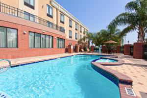 a swimming pool in front of a building at Holiday Inn Express & Suites Wharton by IHG in Wharton