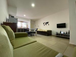 a living room with a couch and a television at Mendoza Apartments Ezeiza Airport in Luis Guillón