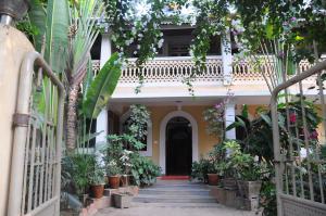 uma casa com um monte de plantas nas escadas em Palolem Guest House em Palolem