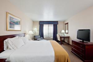 a hotel room with a bed and a flat screen tv at Holiday Inn Express & Suites Jackson by IHG in Jackson +15 photos