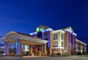 EnidにあるHoliday Inn Express Enid-Highway 412 by IHGの夜に看板が掲げられたホテルの建物