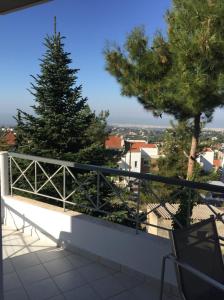 a balcony with a tree and a white railing at Respect to the Guest in Thessaloniki