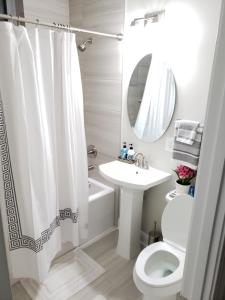 y baño con cortina de ducha blanca, lavabo y aseo. en Spacious & Bright home In Bloomingdale/ Truxton DC en Washington
