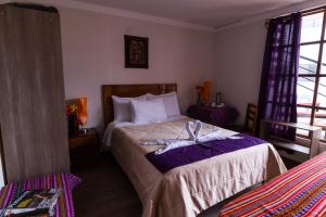 Un pat sau paturi într-o cameră la Askha Cusco