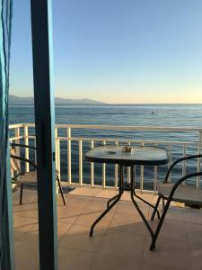 a table and chairs on a balcony overlooking the ocean at Dimitra Beach Apartments - Nea Karvali Kavala in Nea Karvali