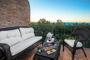 a couch on a patio with a table and chairs at Luxury villa with sea views - heated pool-Jacuzzi in Benalmádena