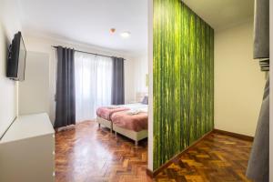 ポンタ・デルガダにあるPassal Hostelの緑の壁、ベッド付きのベッドルーム1室