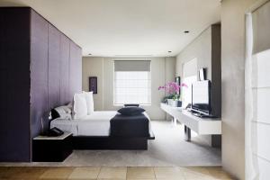 a bedroom with a bed and a desk and a tv at Establishment Hotel in Sydney