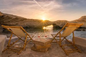 2 chaises et une table avec 2 verres de vin dans l'établissement AQUA HOUSE, à Pachaina