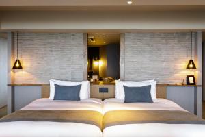 two beds sitting next to each other in a bedroom at Glamday Style Okinawa Yomitan Hotel & Resort in Yomitan