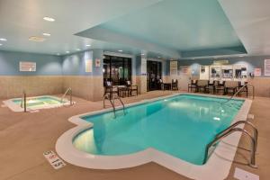 einen Pool in einem Hotelzimmer mit Tischen und Stühlen in der Unterkunft Holiday Inn Express Hotel & Suites Fort Wayne, an IHG Hotel in Fort Wayne