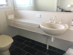 
a white toilet sitting next to a sink in a bathroom at Rosewhite House in Myrtleford
