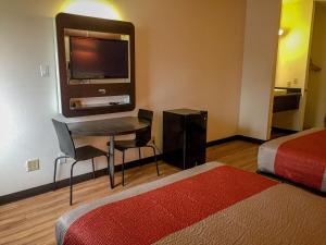 Habitación de hotel con escritorio y TV. en Motel 6-Woodway, TX en Woodway