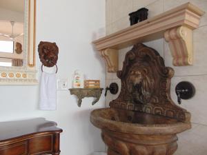 a bathroom with a stone sink with a lion on the wall at Poco Cielo Hotel in Rosarito