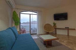 a living room with a blue couch and a balcony at Gaviana Resort in Mazatlán