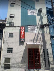 un edificio con una puerta roja y un cartel en él en HOTEL PAULISTANO Parque Anhembi en São Paulo